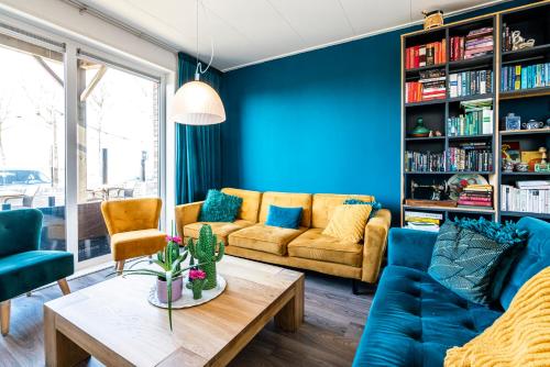 卡德赞德Bruist的客厅设有蓝色的墙壁、一张沙发和一张桌子