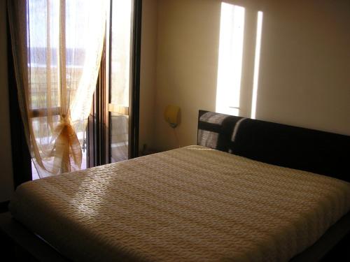 圣维托罗卡波Baglio Makari的一间卧室配有床和带窗帘的窗户