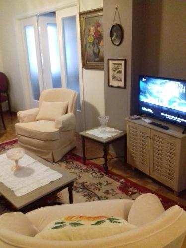 雅典George appartment的客厅配有电视、沙发和椅子