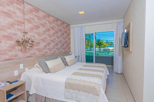 瓜拉图巴Hotel VillaReal Charme的一间卧室配有一张床,享有海景
