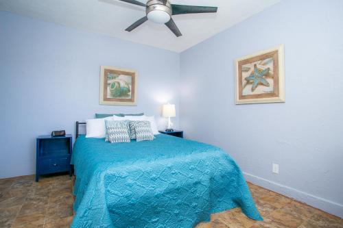 博尔德城NV Best的一间卧室配有一张蓝色的床和吊扇