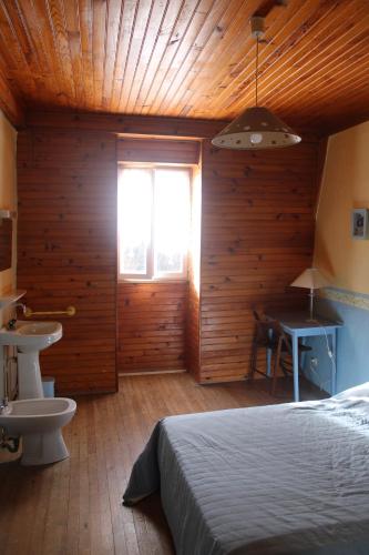 La Salvetat-PeyralèsAuberg'IN !的一间卧室配有床、水槽和窗户