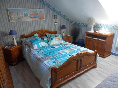 滨海贝尔克L Imperatrice的一间卧室配有一张带蓝色枕头的大型木制床。