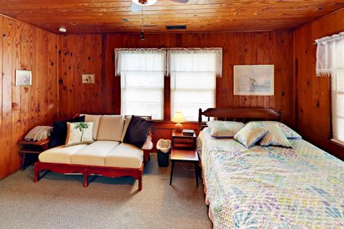 默特尔比奇Vintage Bungalow的一间卧室配有一张床、一张沙发和一把椅子