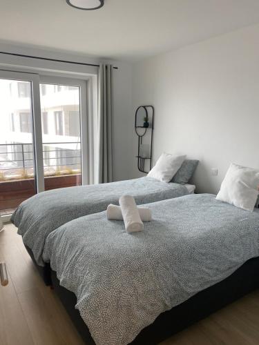 奥斯坦德Lichtrijk 2-slaapkamerappartement met zeezicht en gratis parking的一间卧室配有两张床和白色毛巾