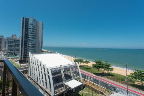 维拉维尔哈SUÍTE ITAPARICA Praia Dourada的阳台享有建筑和海滩的景致。
