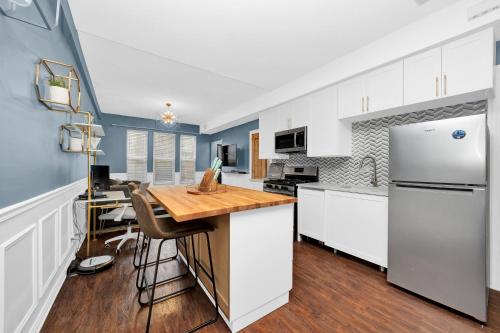 芝加哥Modern 2 Bedroom in Avondale的厨房配有白色橱柜和木制台面