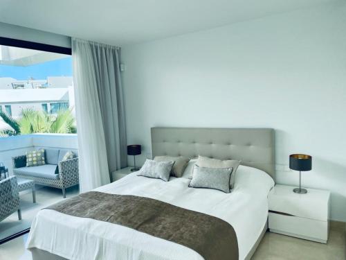 米哈斯科斯塔Serenity by the Sea in La Valvega, La Cala的白色卧室设有一张大床和一个阳台