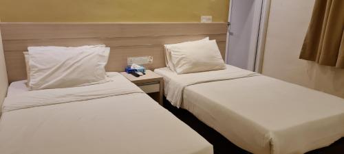 关丹Star Tree Homestay -Contactless Self Check in的配有2张床铺的酒店客房,提供白色床单和枕头