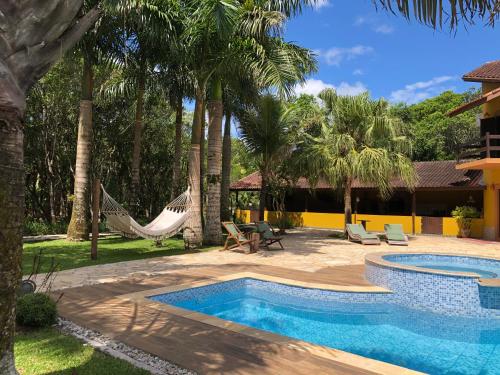 卡纳内亚Jardim Boêmio的一个带吊床的游泳池和一个度假村