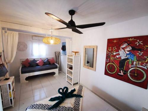 吉利特拉旺安Sahara Sands Guest House - Gili Trawangan的客厅配有吊扇和沙发。