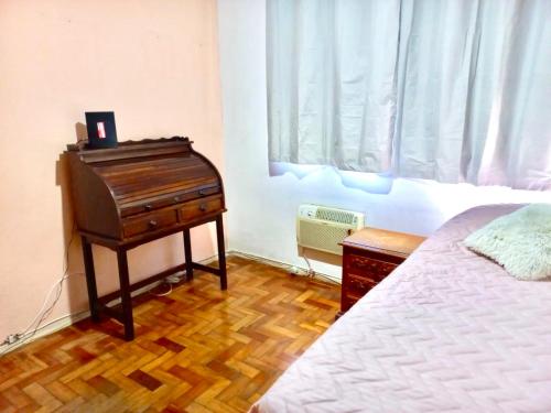 里约热内卢Aconchego no Rio的卧室配有钢琴,位于床边