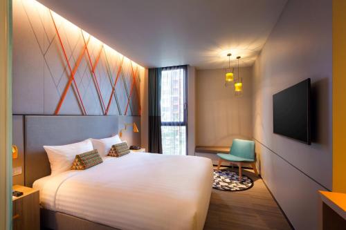 曼谷宜必思尚品曼谷素坤逸康福酒店的酒店客房,配有床和电视