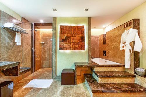 尼杜巴塞莱Flora Airport Hotel and Convention Centre Kochi的带浴缸、水槽和淋浴的浴室