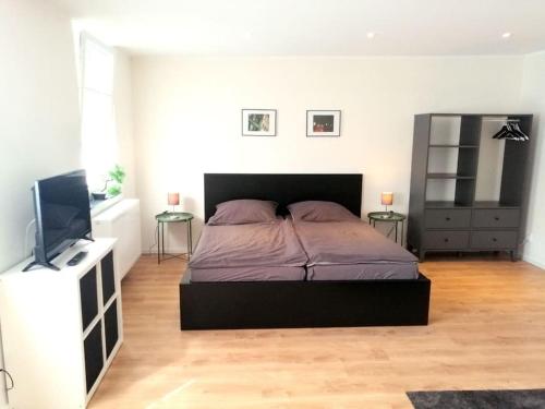 科隆Apartment - Neu, modern, gemütlich, eigener Parkplatz的一间卧室配有一张床和一台平面电视