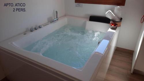 VillelEl Tranco Apartamentos的浴室内设有蓝色水按摩浴缸。