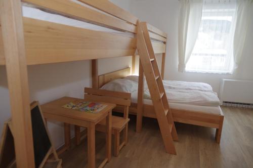 德尔内夫奥里克Apartmá 11 Deštné v Orlických horách的一间卧室设有两张双层床和一张桌子