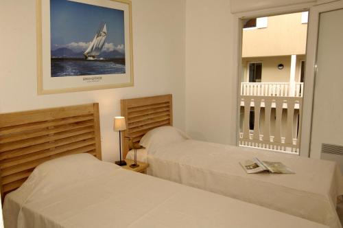 阿卡雄Lagrange Vacances - Villa d'Este的卧室配有两张床,墙上有一艘帆船