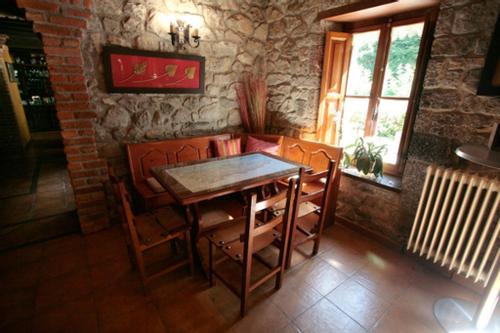 因菲耶斯托Hotel Rural Casa Cueto的一间带木桌和椅子的用餐室