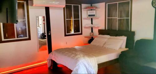 阿瓜达Ariami Rose的一间卧室配有一张带绿色床头板和窗户的床。