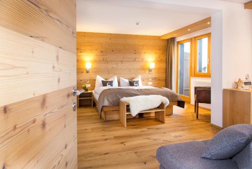 贝特默阿尔卑Hotel Bettmerhof的一间卧室设有一张床和木墙