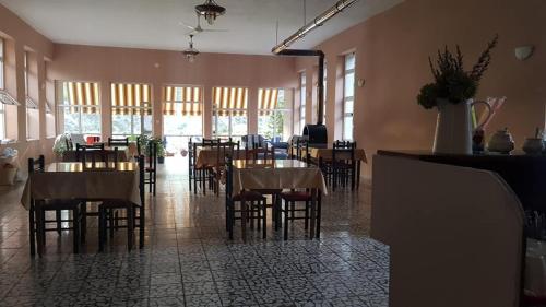 KomanAgroturizem Hotel Vila Franceze的一间在房间内配有桌椅的餐厅