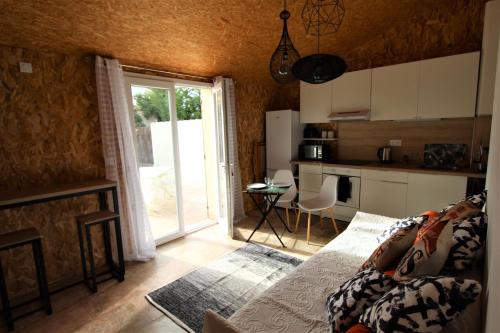 索尔格河畔利勒Les Bastidons de l'Isle - Le Saumane - 3 étoiles的带沙发的客厅和带窗户的厨房