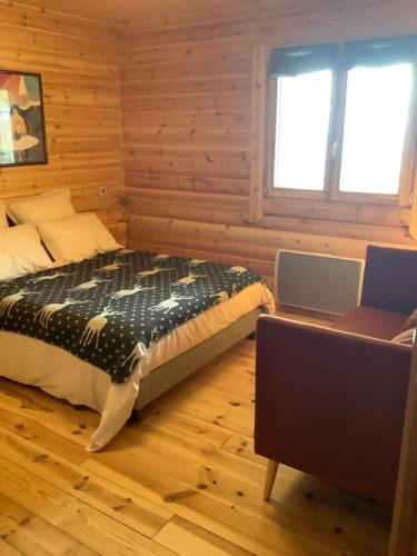 ÉgatChalet Les Sorbiers的卧室配有一张床铺,位于带木墙的房间内