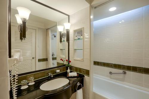 仰光仰光宾乐雅酒店的一间带水槽、浴缸和镜子的浴室