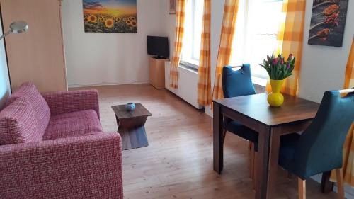 吕贝克1-Zimmer-Apartment-2-Hochparterre的客厅配有桌子、沙发和椅子