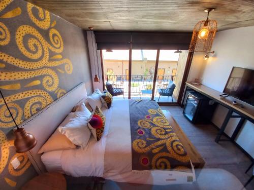 维库尼亚Solar Madariaga Hotel的一间卧室配有一张带壁画的床