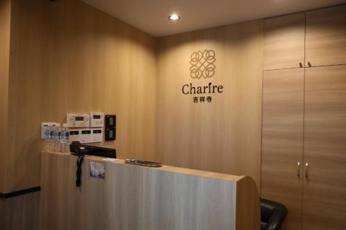 KichijōjiHotel Charire Kichijoji的墙上有标牌的办公室柜台