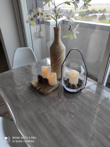 库尔瑟勒·苏尔·梅尔Appartement de charme的一张桌子,上面有蜡烛和花瓶
