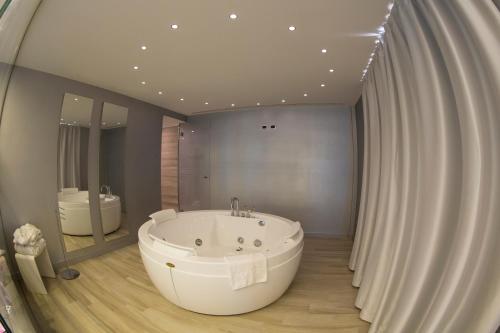 卡梅里卡梅利亚汽车旅馆的一间带大型白色浴缸和镜子的浴室