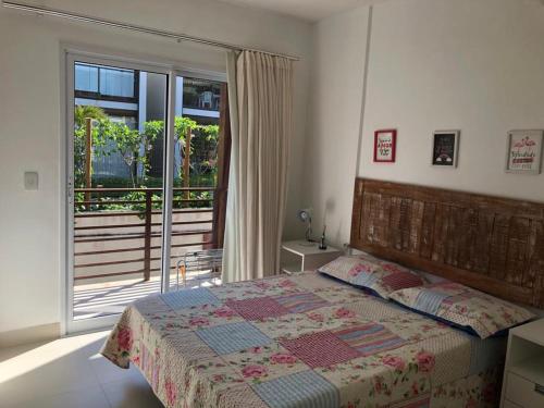伊塔齐米林Areias de Itacimirim 104 Village - Pé na Areia的一间卧室设有一张床,享有阳台的景色