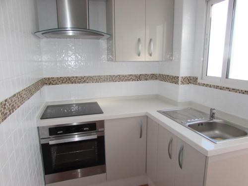 韦尔瓦Luz y Mar Huelva-Ático的白色的厨房设有水槽和炉灶。