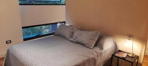 查克拉斯德科里亚LOFT MIC的卧室配有带枕头的床铺和窗户。
