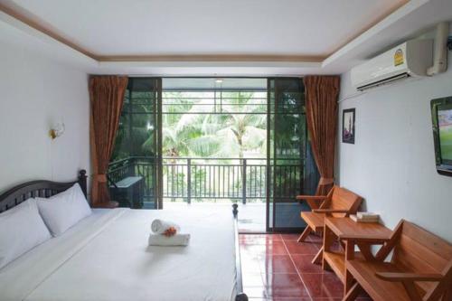 卡马拉海滩Kamala bay inn的一间带白色床的卧室和一个阳台