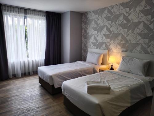 莎阿南SRITEL BOUTIQUE HOTEL的酒店客房设有两张床和窗户。