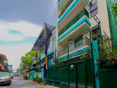 马尼拉OYO 840 Orangenest Apartelle的停在绿色建筑旁边的一个停车位