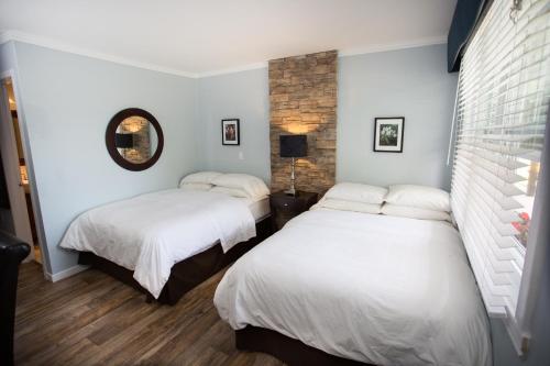 布罗蒙布罗蒙公寓式酒店的配有白色墙壁和木地板的客房内的两张床