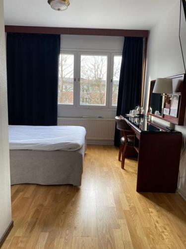 隆德Place Lund的一间卧室配有一张床、一张书桌和一个窗户。
