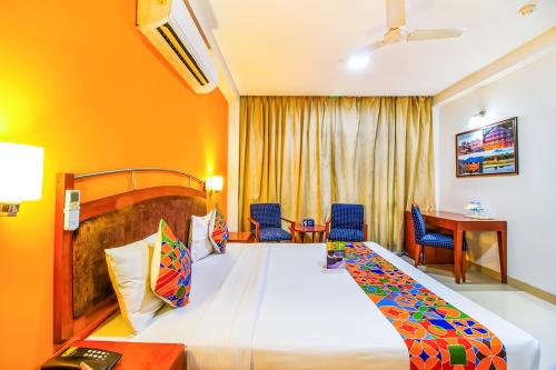 新德里FabHotel F9 NFC的酒店客房带一张大床和椅子