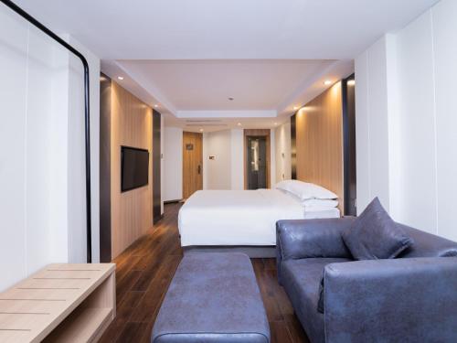 上海丽怡酒店·上海浦东机场川沙地铁站店的酒店客房,配有床和沙发