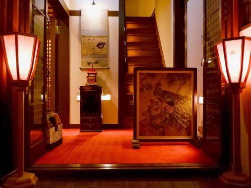 京都祇园紘酒店的走廊上设有一幅画作和两盏灯