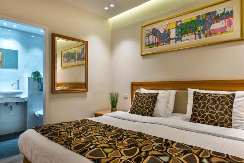 埃拉特Melio Hotel Eilat的一间卧室配有一张大床和镜子
