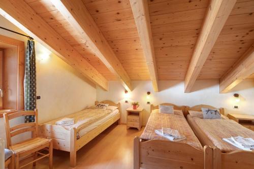 利维尼奥Baita Bruno Fior di Loto的配有木天花板的客房设有两张床。