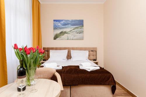 米兹多洛杰Villa Nadzieja的一间卧室配有一张床和一张鲜花桌子