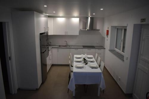 费雷尔Casa do Sapateiro的厨房配有带白色桌布的桌子