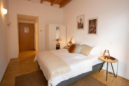 TholeyHotel Hofgut Imsbach Lapointe的卧室配有一张白色的大床和一张桌子